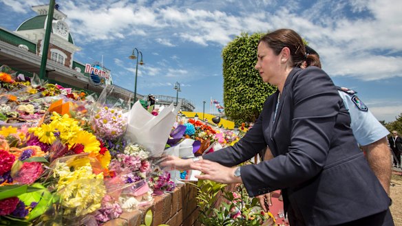 Queensland Premier Annastacia Palaszczuk places flowers at the makeshift memorial outside Dreamworld in 2016.