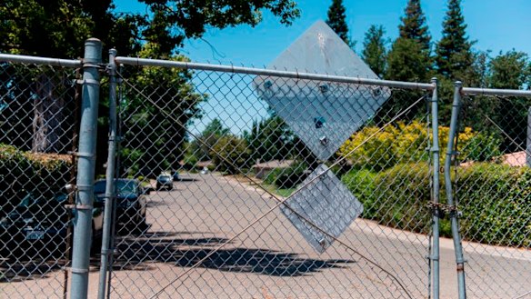 The levee behind this fence led to areas of thick brush and the American River, which the suspect often used to make his escape. 