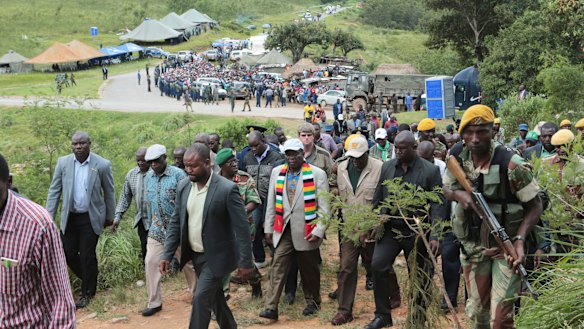 Zimbabwean President Emmerson Mnangagwa, centre with scarf, visits Chimanimani.
