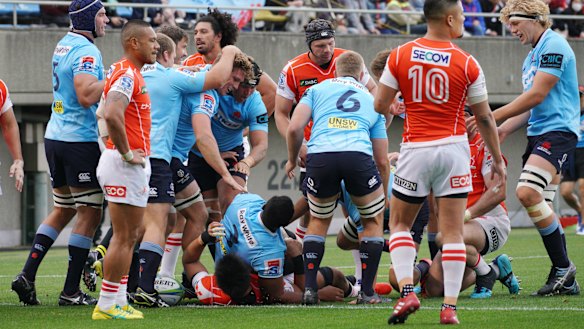 Try blitz: The Waratahs celebrate after another try in a high-scoring affair at Chichibunomiya Rugby Stadium.