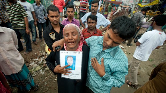 A woman holds a picture of her son, who went missing in the Rana Plaza building collapse in 2013 in Bangladesh.