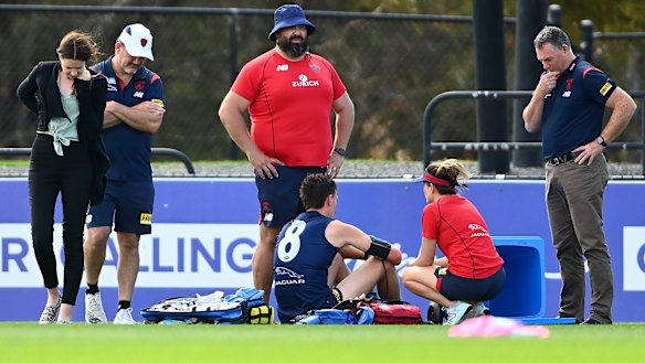 Melbourne medical staff, as well as Alan Richardson, attend to star defender Jake Lever after he fainted during training at Casey Fields. 
