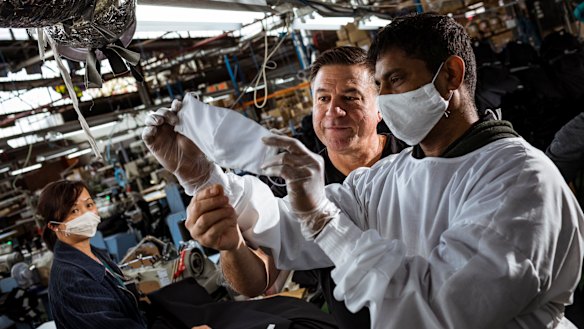 Nobody denim co-founder John Condilis inspects a mask prototype with cutting machinist K Yokachanthiran. The company is hoping to win a government PPE contract to save jobs.