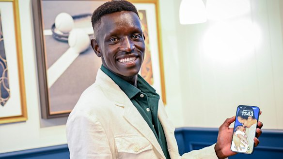 Proud father Peter Bol shows off a photo of fiancee Mahtut Yaynu and baby Reyna. 