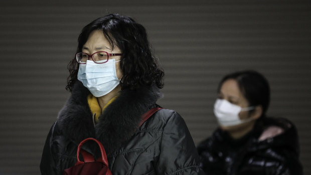 A woman wears a mask at a subway station in Wuhan, where the number of confirmed cases of the new coronavirus has jumped sharply.