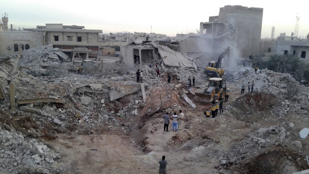 White Helmets and civilians inspecting damaged buildings after airstrikes hit in the village of Zardana, in Idlib province, in June.