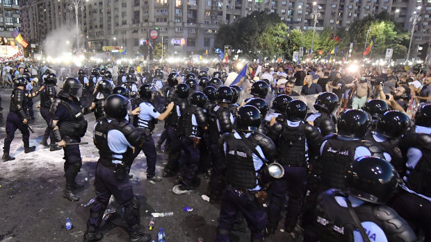Riot police charge to clear the square during protests outside the government headquarters in Bucharest. 