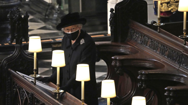The Queen stands as Prince Philip’s coffin is carried into St George’s Chapel.