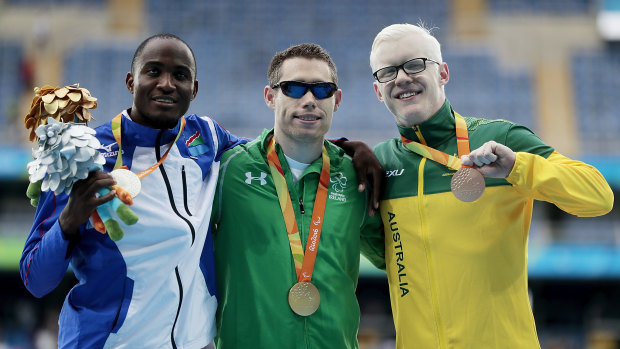 Perris (right) receives his gold medal in Rio after the men’s T13 100m event. 