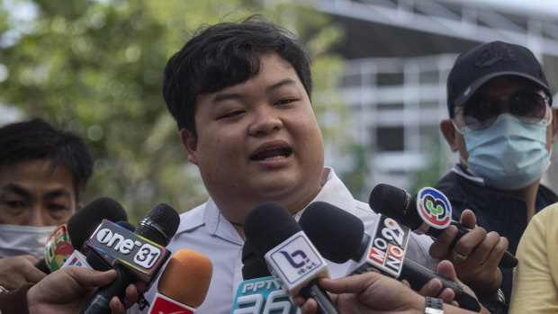 Activist Parit "Penguin" Chiwarak talks to reporters before one of his court appearances in Bangkok.