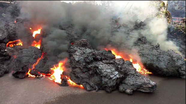 A lava flow advances down a road in the Leilani Estates subdivision near Pahoa on the island of Hawaii on Monday.