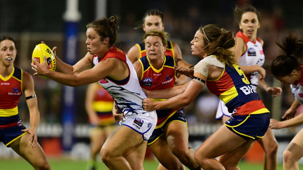 Hard and fast: Bulldog Ellie Blackburn gets caught in a tackle by the Crows' Courtney Cramey.