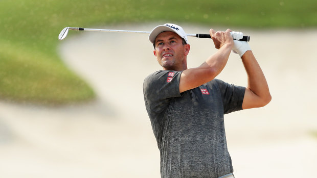 Adam Scott plays out of a fairway bunker on the 18th hole.