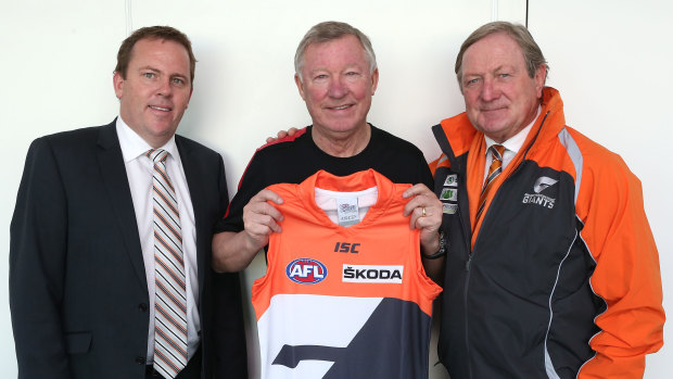 Giants CEO David Matthews and coach Kevin Sheedy flank legendary Manchester United manager Sir Alex Ferguson in a classic “No Sherrin” rule breach in 2012.