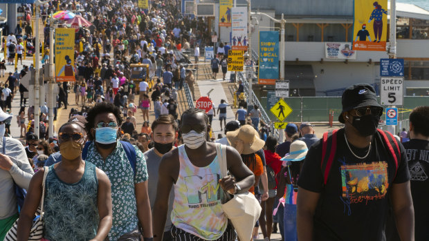 People crowd the Santa Monica Pier in Santa Monica, California, as the state turns a page on the pandemic. 