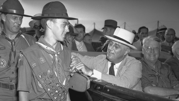 Then US president Franklin D. Roosevelt stops briefly to pin an Eagle Badge, highest honour of "scoutdom", on the chest of Franklyn C. St. John in 1937.