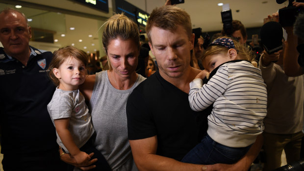 In the eye of the storm: Dave Warner and his family arrive back in Sydney in the wake of the Cape Town ball-tampering scandal.