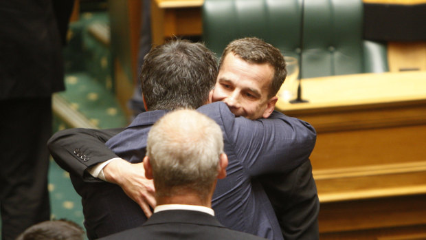 Euthanasia bill sponsor David Seymour, rear right, embraces other MPs in Parliament in Wellington, New Zealand, on November 13.