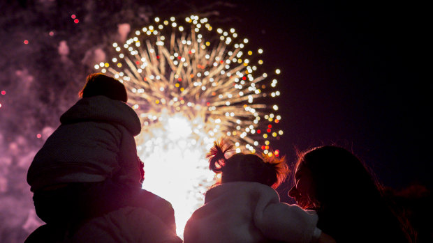 A family watches the New Year's Eve fireworks in Melbourne.