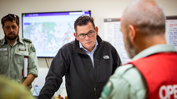 Premier Daniel Andrews is briefed by emergency services personnel. 