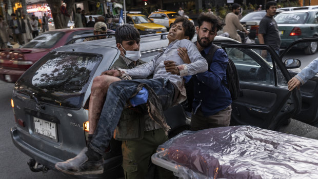 A person wounded in a bomb blast outside the Kabul airport in Afghanistan arrives at a hospital.