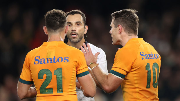 Referee Mathieu Raynal speaks to Nic White and Bernard Foley.