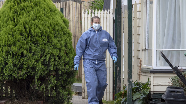 A forensic officer searches the home in Phair Court, Altona, where two people were arrested.