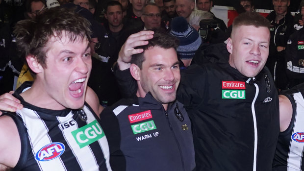 Injured Magpies Levi Greenwood (centre) and Jordan De Goey (right) could still enjoy the celebrations with Darcy Moore.