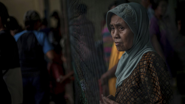 A survivor pauses at a temporary shelter for those affected by Saturday's tsunami in Carita, Indonesia.