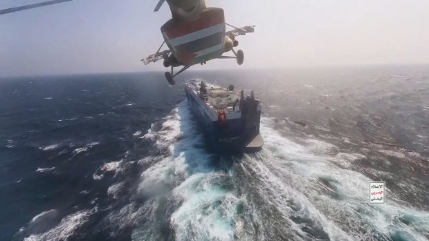 A Houthi helicopter approaches a cargo ship in the Red Sea as the rebels threaten to seize vessels owned by Israeli companies.