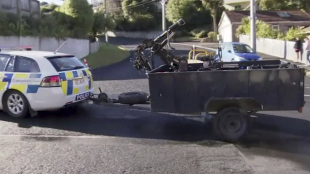 A flurry of activity. A police vehicle tows bomb disposal robot on the way to their investigation of the shooter's home in Dunedin, New Zealand.