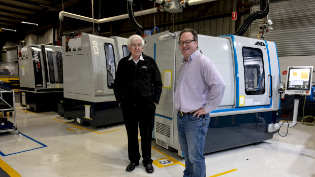 Pat Boland, co-founder and director of ANCA and Mark Patman at ANCA's factory in Bayswater with the machines manufacturing components for the ventilators. 