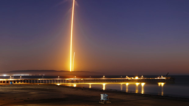 Two streaks in this long exposure photo show the SpaceX Falcon 9 rocket lifting off, left, from Vandenberg Air Force Base.