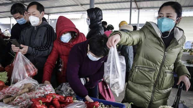 Wuhan residents wear masks to buy vegetables.