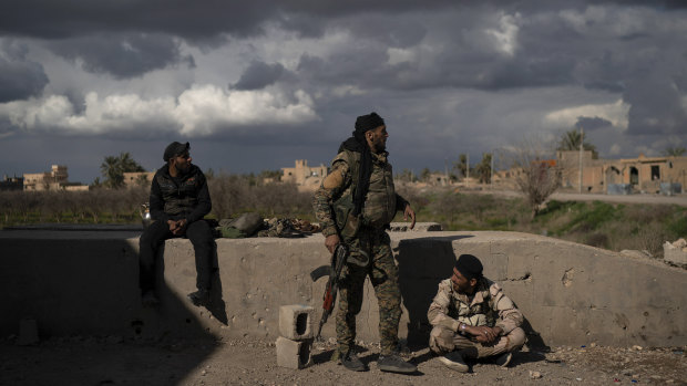 US-backed Syrian Democratic Forces (SDF) fighters stand in an area recently taken by SDF as fighting against Islamic State militants continues in the village of Baghouz, Syria, on Sunday.