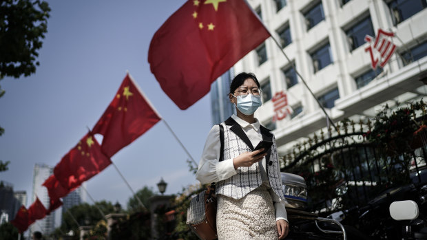 A women wears a face mask as she passes a hospital gate in Wuhan. 