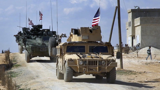 A frame grab from video provided by Arab 24 network shows U.S. forces patrol on the outskirts of the Syrian town Manbij.