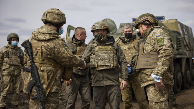 Ukrainian President Volodymyr Zelenskiy shakes hands with a soldier as he visits the war-hit Donbas region, in eastern Ukraine.