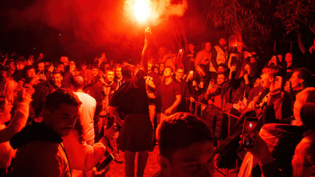 A soccer fan lets off a flare at Melbourne’s Federation Square during the Socceroos’ World Cup match.