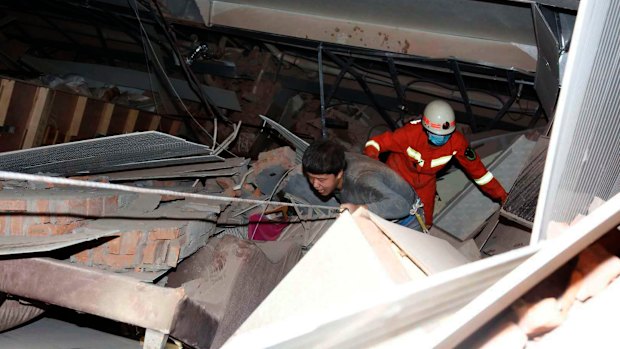 A man is assisted out from the rubble of the collapsed hotel building. 