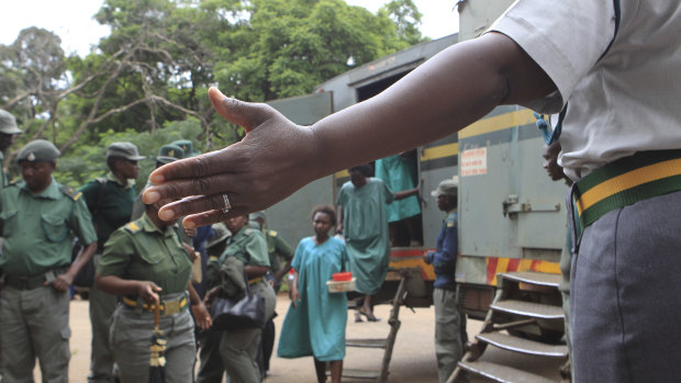 A prison guard directs some of the people arrested during protests as they arrive to make their magistrates court appearance last week.