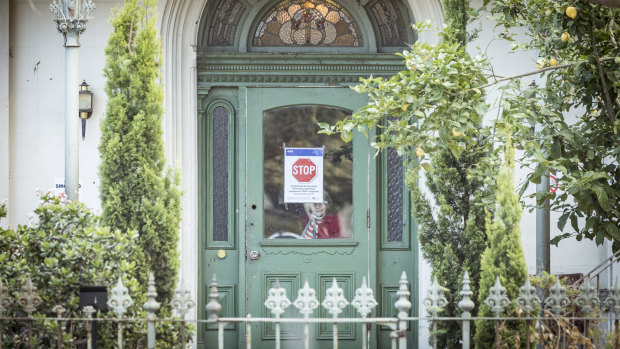 One resident peers from inside the locked down home on Monday morning.