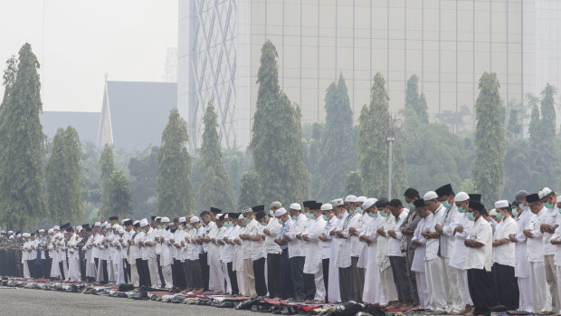 Arms clasped, Muslims pray for rain in Pekanbaru, Riau province, Indonesia.