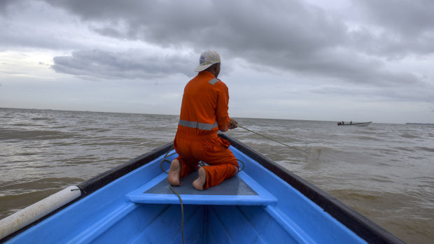 A fisherman  rides in a boat where some have been either robbed and/or killed by Venezuelan pirates.