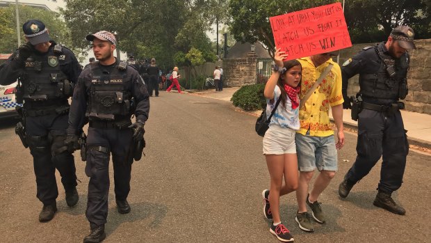 Izzy Raj-Seppings, 13, is led away from the protest  in December 2019 at Kirribilli House after police issue a move on order. 