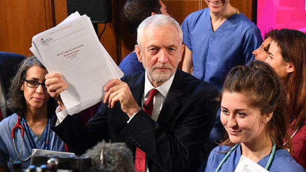 Labour leader Jeremy Corbyn poses with members of NHS staff as he presents documents related to post-Brexit UK-US trade talks.