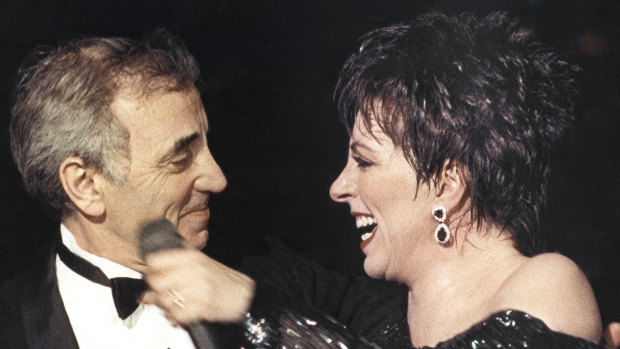 Liza Minnelli welcomes Charles Aznavour onto the stage at the end of her show at the Lido cabaret in Paris in 1987.