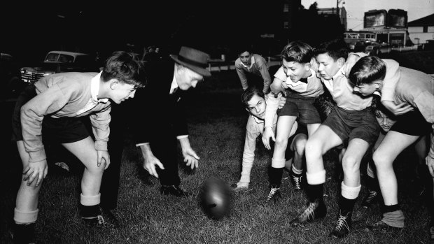 Mentor: Dally Messenger feeds a training scrum with a group of young footballers.