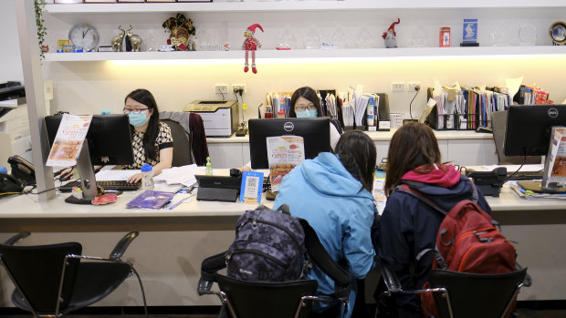 Travel agents wear masks at a store in Melbourne earlier this year.