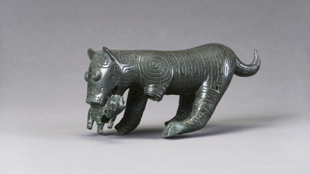 A bronze sculpture of a tiger mother with cub in its mouth from the Western Zhou Dynasty, 1046–771 BCE. 